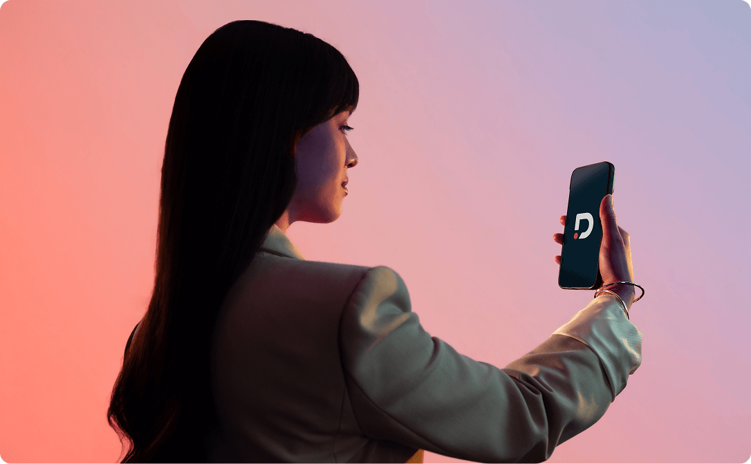 Modern image of woman looking at a mobile phone which is showing the Dragonpass logo